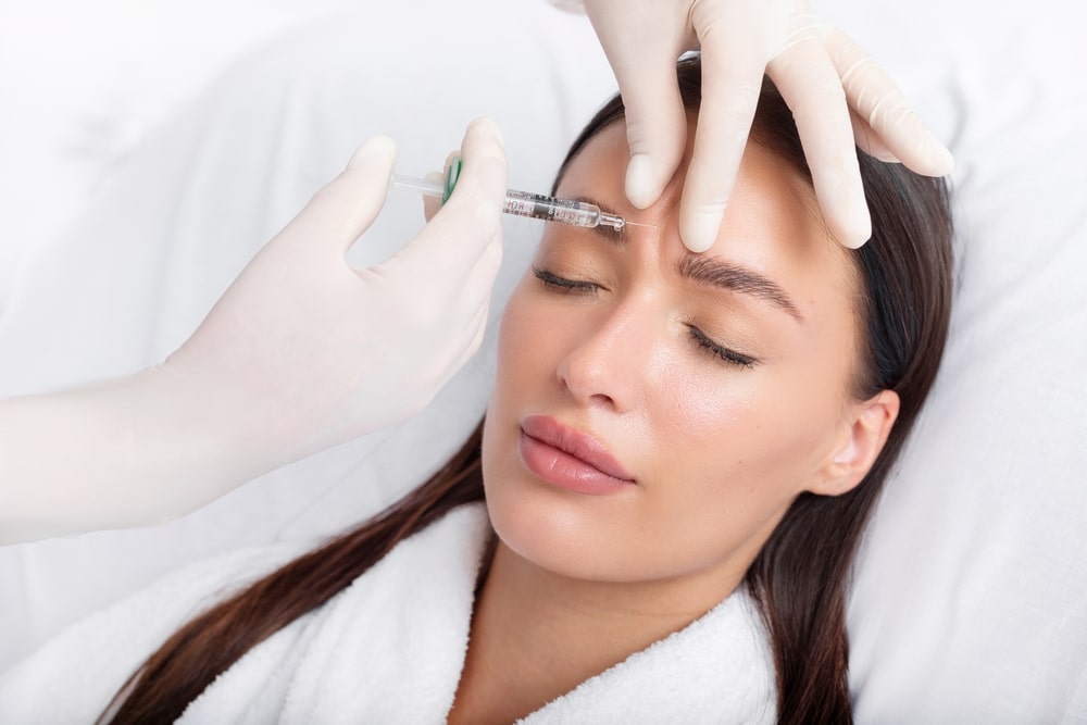 Relaxed woman getting BOTOX injections in forehead in Ashburn, VA